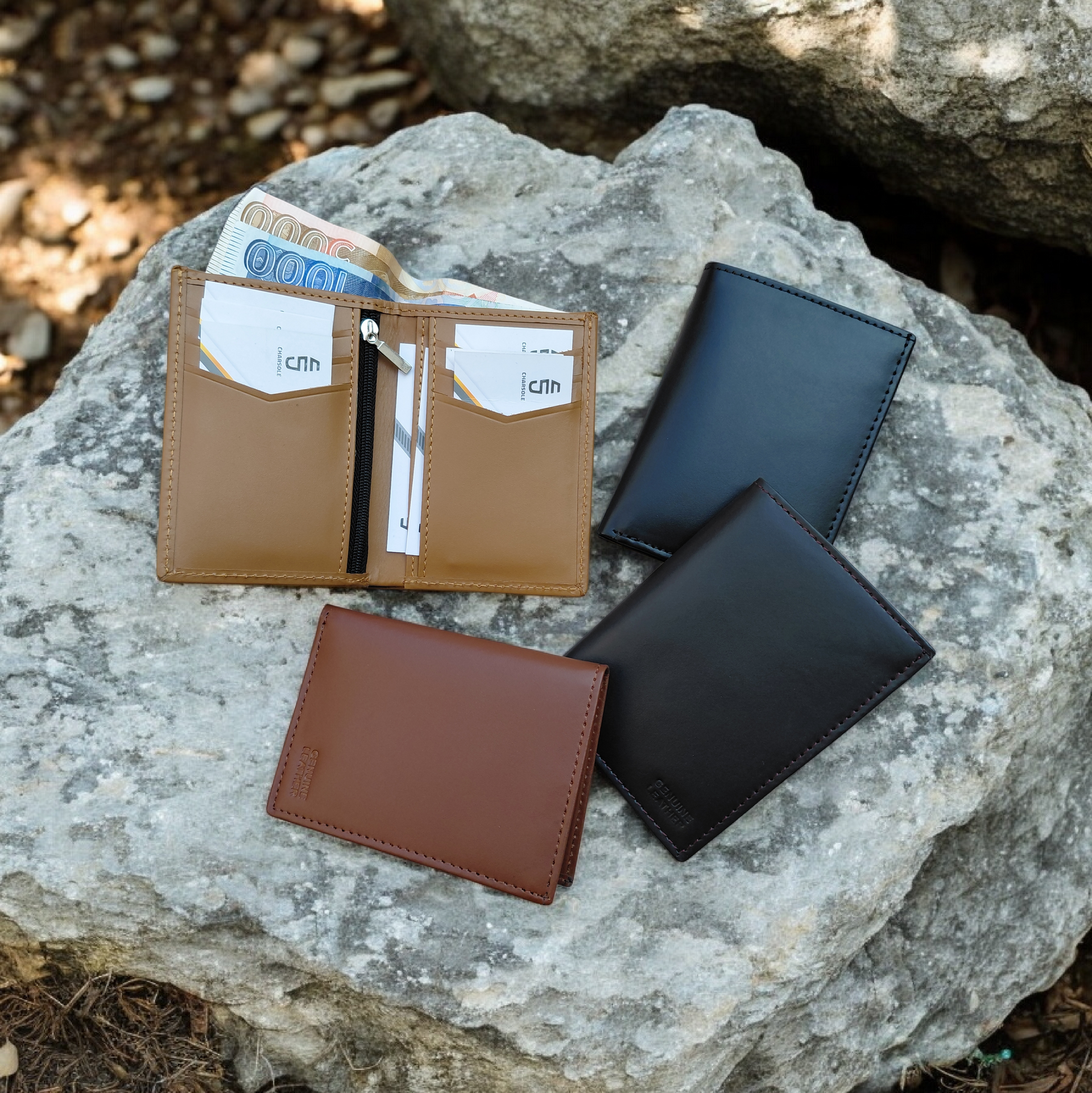 Four leather wallets in different colors on a rock