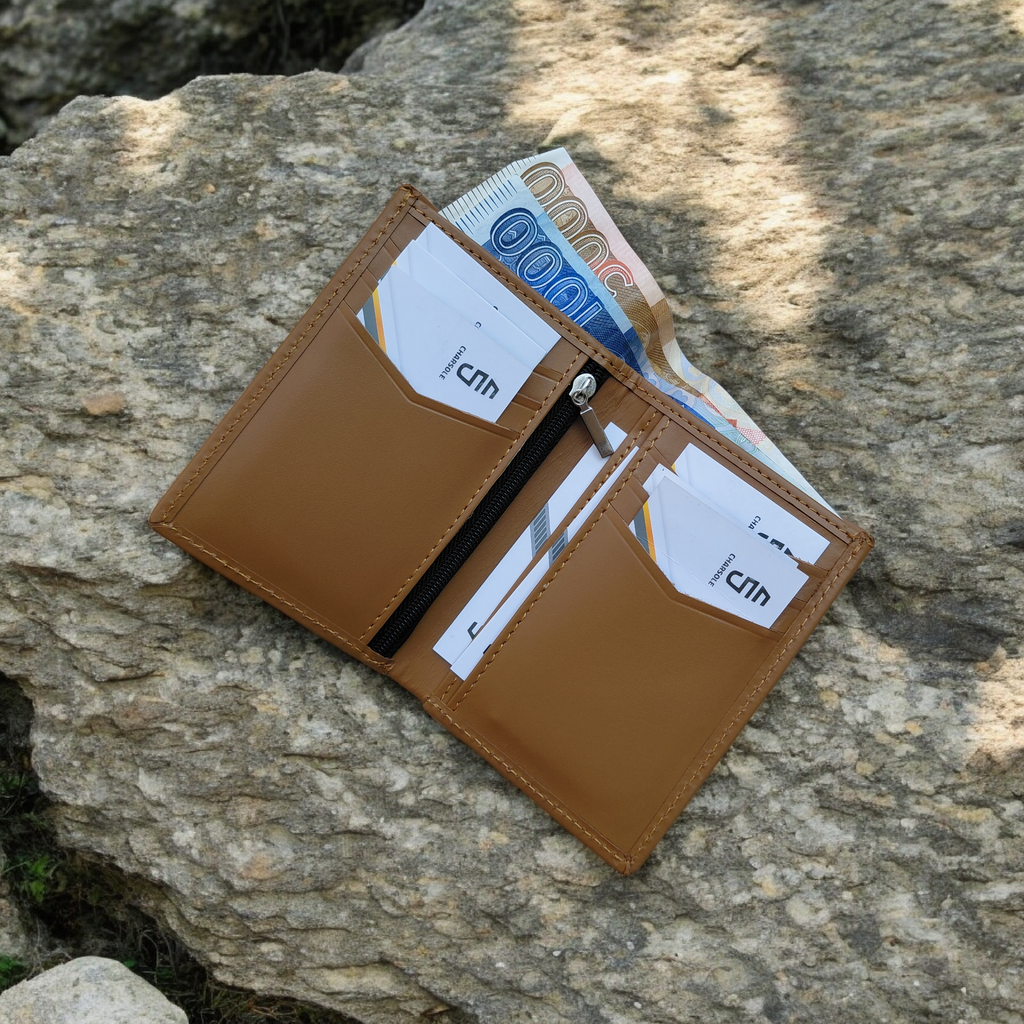 Brown leather wallet with cards and money on a stone surface